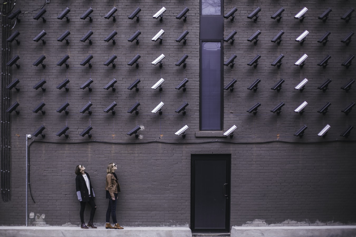 Two Women looking at lots of security cameras